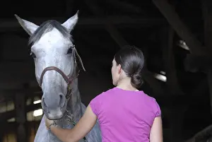 Stable: Young woman and her horse in an equestrian center France