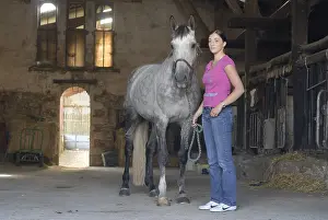 Stable: Young woman and her horse in an equestrian center France