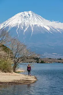 Lakeland: Young woman on the shore, view over a lake to the
